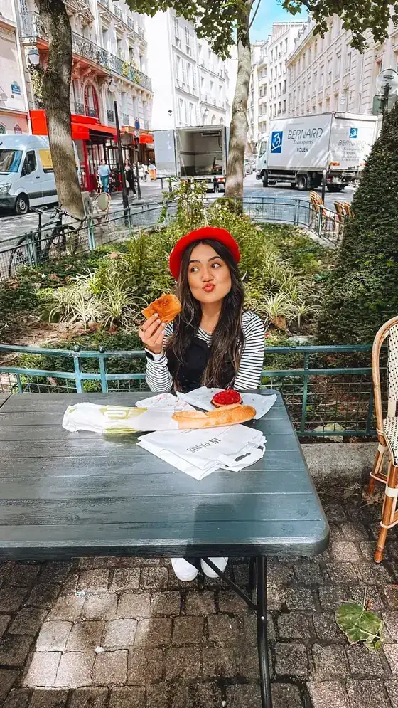 Página do guia: Camila de boina vermelha numa mesa de café