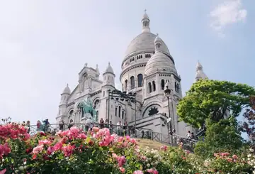 Basílica do Sacré-Cœur com canteiros de flores cor-de-rosa